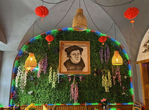 "Luther meets Sushi"<br>(Gedenkwand im Asia-Restaurant neben Luthers Geburtshaus in Eisleben, Aug. 2025)